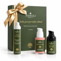 Sada pro pevnější vzhled pleti a oční okolí NERELI, 3 produkty – kompozice se zlatou mašlí na bílém pozadí
